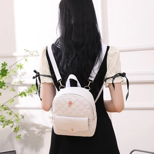 Fashionable white quilted backpack with floral decoration and golden hardware details