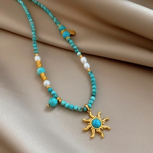 Collier bohème en perles de turquoise et nacre avec pendentif soleil doré vintage