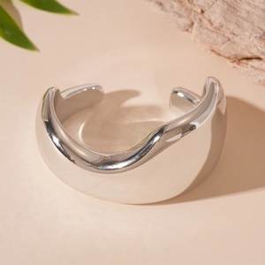 Detailed view of irregular wavy silver cuff bracelet with a polished mirror finish