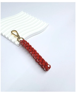 Detail of red and white woven keychain featuring a gold rotating spring metal clasp