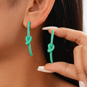 Orecchini a nodo minimalisti verde menta opaco, mostrati indossati per scala e dettaglio