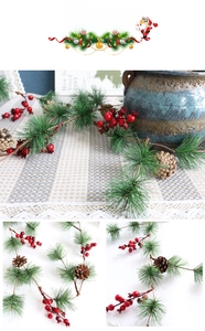Close-up of Christmas garland with pine needles, red berries and natural pinecones
