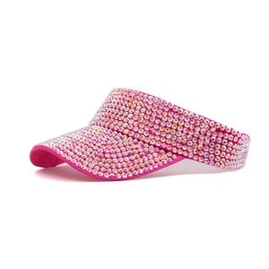 Detail of hot pink sun visor hat covered in shimmering rhinestones for summer