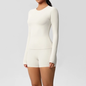 Detail of high-waist yoga shorts and slim-fit long-sleeve top in brushed cream fabric