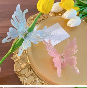 Detail of pink and blue iridescent butterfly hair claws with delicate hollow wing patterns