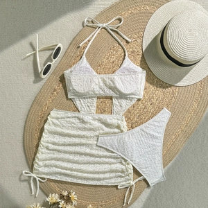 Detailansicht des weißen Jacquard-Stoffs eines dreiteiligen Bikini-Sets mit Strandrock