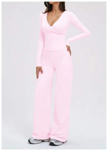 Detail of light pink yoga set featuring a V-neck cross wrap top and high waist flared pants