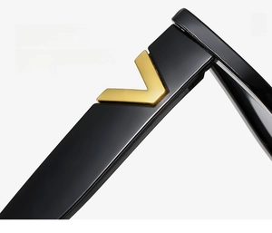 Detailed close-up of glossy black temples with gold V-shaped decorative accents on sunglasses