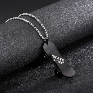 Détail d'un pendentif skate noir avec texte 'SKATE SPIRIT' sur une chaîne argentée