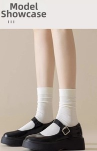 Detailed texture of white cotton mid-calf socks with vintage black Mary Jane shoes