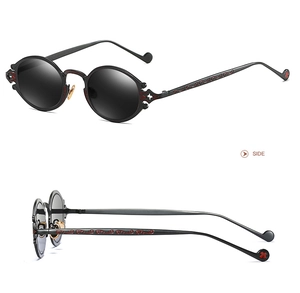 Macro detail of gothic steampunk sunglasses with intricate engraved patterns on dark grey frame