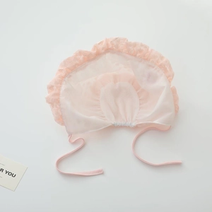 Detailed view of pink lace baby sun hat with delicate mesh texture and ribbon tie