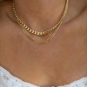 Three-layer chunky gold chain necklace set with Cuban links worn by a model