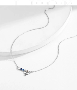 Detail of s925 silver bee and honeycomb necklace with colorful enamel on white steps