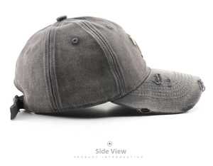 Detail view of washed vintage cotton baseball cap with distressed brim and metal buckle
