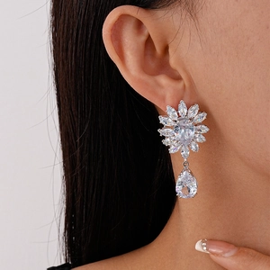 Gros plan de boucles d'oreilles pendantes en argent avec zircons en forme de fleurs