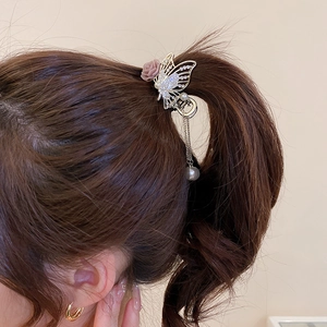 Detail of floral hair claw clip with rhinestones, pearls and elegant tassel on a ponytail