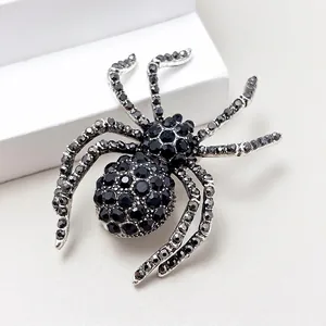 Macro shot of spider animal brooch with black crystals on a silver alloy base