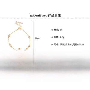Detail view of gold clover bracelet with zircon flower and pearl texture on white background