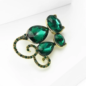 Detailed close-up of emerald green cat brooch with faceted crystals and bronze alloy finish