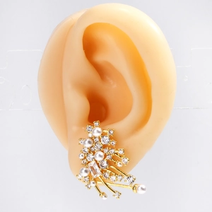 Detailed close-up of gold cluster earrings with white pearls and sparkling cubic zirconia