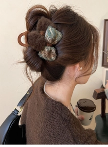 Detail of vintage plush bow hair claw clip with checkered fabric on woman's hair
