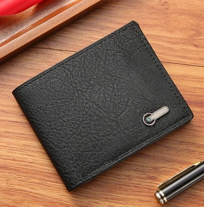Portefeuille pour homme en cuir noir avec logo en métal sur fond en bois marron