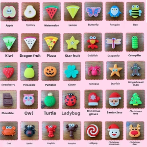 Macro shot of 35 diverse silicone charms featuring fruit, animal and food designs