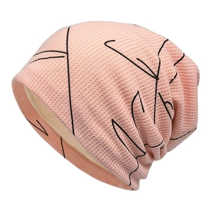 Pink knit slouchy beanie for women featuring black abstract line art and waffle texture
