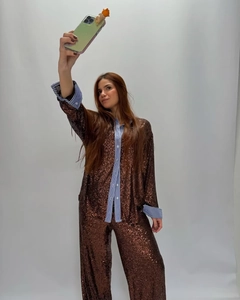 Détail d'une chemise à paillettes marron foncé et d'un pantalon assorti au fini brillant