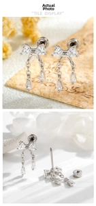 Detail of silver bow tassel earrings with zircon heart studs and long chain fringes