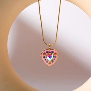 Golden necklace featuring a pink heart locket with colorful stones and star accents