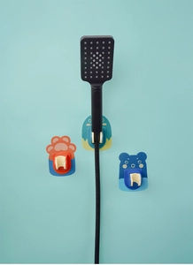 Wall-mounted cartoon shower head holders in orange cat paw and blue bear designs