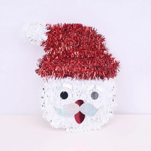 Close-up of tinsel Santa Claus ornament with shiny sequins and bright red festive details