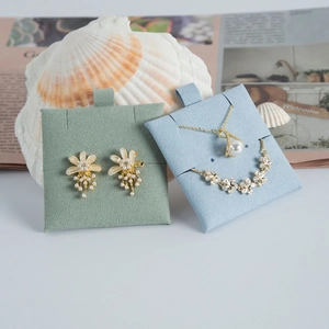 Detail of floral jewelry set featuring pearl necklace and gold earrings on soft fiber pads