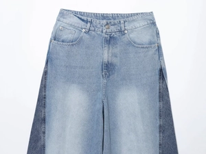 Detail of high-waisted wide leg jeans featuring contrast denim patchwork design