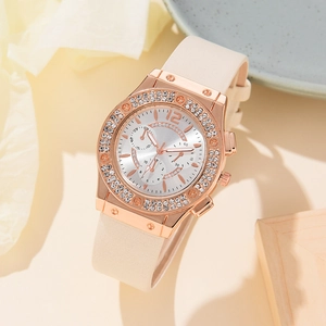 Close-up of a rose gold rhinestone watch with a beige strap and detailed chronographs