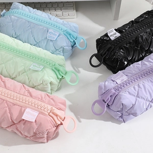 Close-up of quilted nylon pencil cases with large plastic zippers in 5 pastel colors