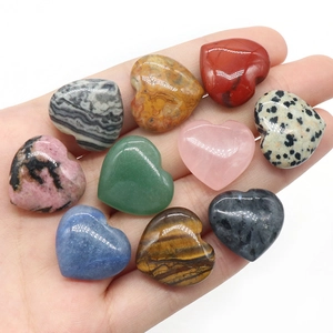 Set of 20mm heart-shaped natural crystal stones displayed in a hand showing various textures