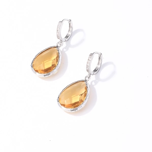 Detail of silver drop earrings featuring yellow gemstones and zircon accents