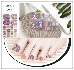 Detail view of purple and gold foil toenail stickers with rhinestone accents for summer