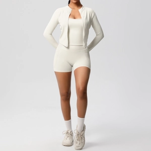 Gros plan sur l'ensemble de yoga beige avec veste zippée, débardeur et short moulant