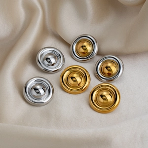 Boucles d'oreilles disques minimalistes en or et argent sur un tissu de soie