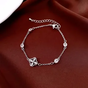 Silver plated floral oval bracelet featuring clover zircon pendant on silk background