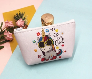 Close-up of white unicorn coin purse with cross-grain texture and Be Cool graphic
