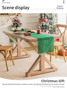 Detailed view of green hollow crochet Christmas table runner on a solid wood table