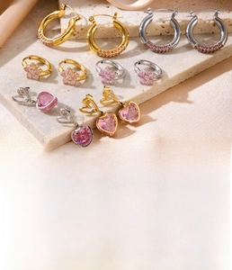 Detail view of titanium steel heart and flower earrings set with zircon and gold plating
