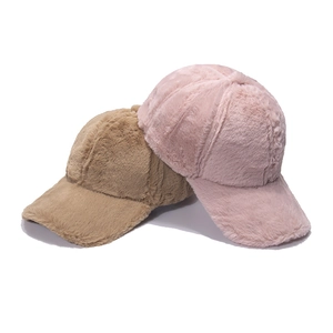 Detail view of winter plush baseball caps in camel and light pink with soft faux rabbit fur