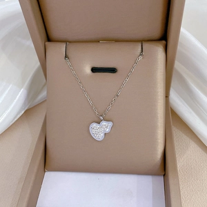 Close-up of silver heart necklace with crystal inlay in a beige jewelry gift box