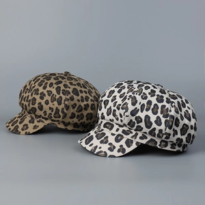 Detail of two leopard print newsboy hats in dark brown and creamy white fabric